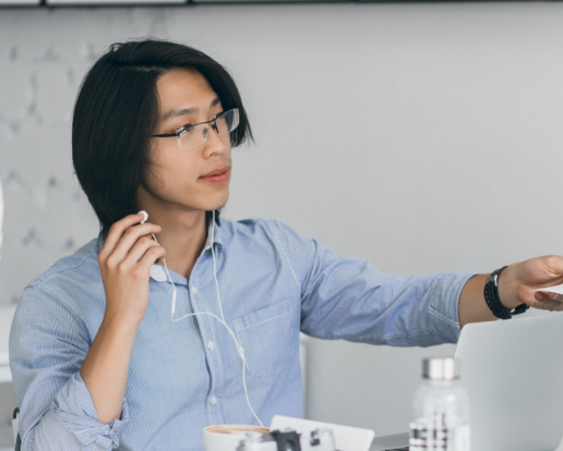 Asian Office Worker Handed Documents Colleague Indoor Portrait Brunette Freelance Programmer Earphones Sitting With Laptop Camera While Drinking Coffee 1